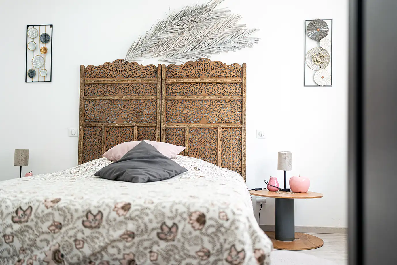 Photo immobilière montrant un grand lit avec une tete de lit en bois