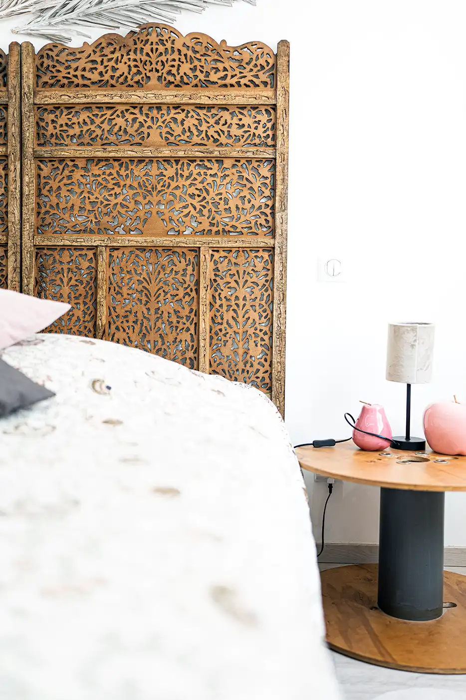 Photo immobilière montrant un grand lit avec un tete de lit en bois