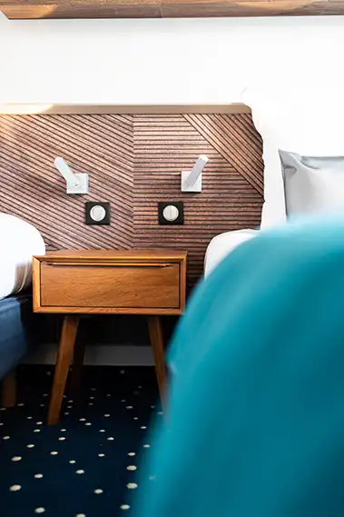 Photo immobilier montrant une table de chevet entre deux lits