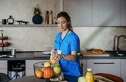 Female Caregiver Assisting with Meal Preparation in the Kitchen - Dedicated In-Home Care Services