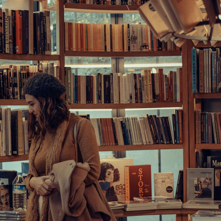 A woman searches for books in a book shop.