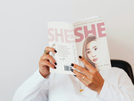 An image of a woman reading a book that blocks her face.