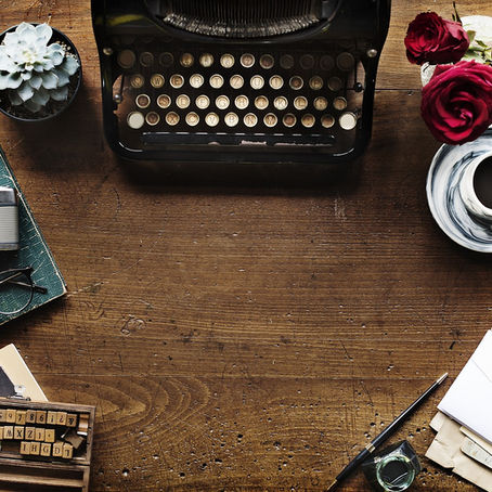 A wooden desk with old fashioned object. typewriter, camera, glasses, notebook