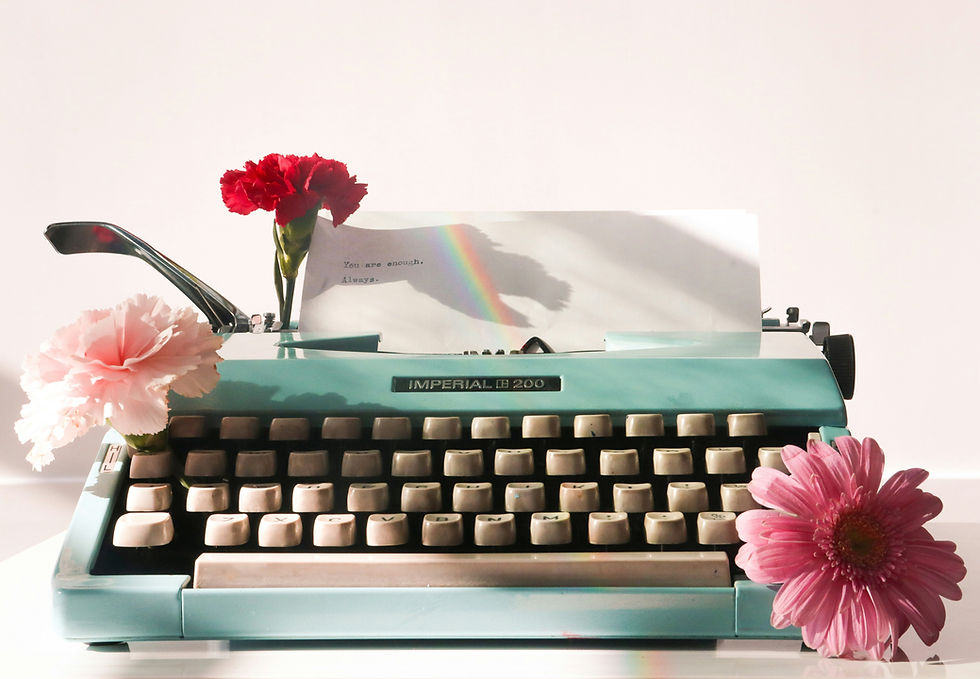 A manual typewriter with flowers around it.