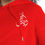 Thumbnail: Christmas White Deer Written In Arabic Calligraphy front view on a red hoodie close up