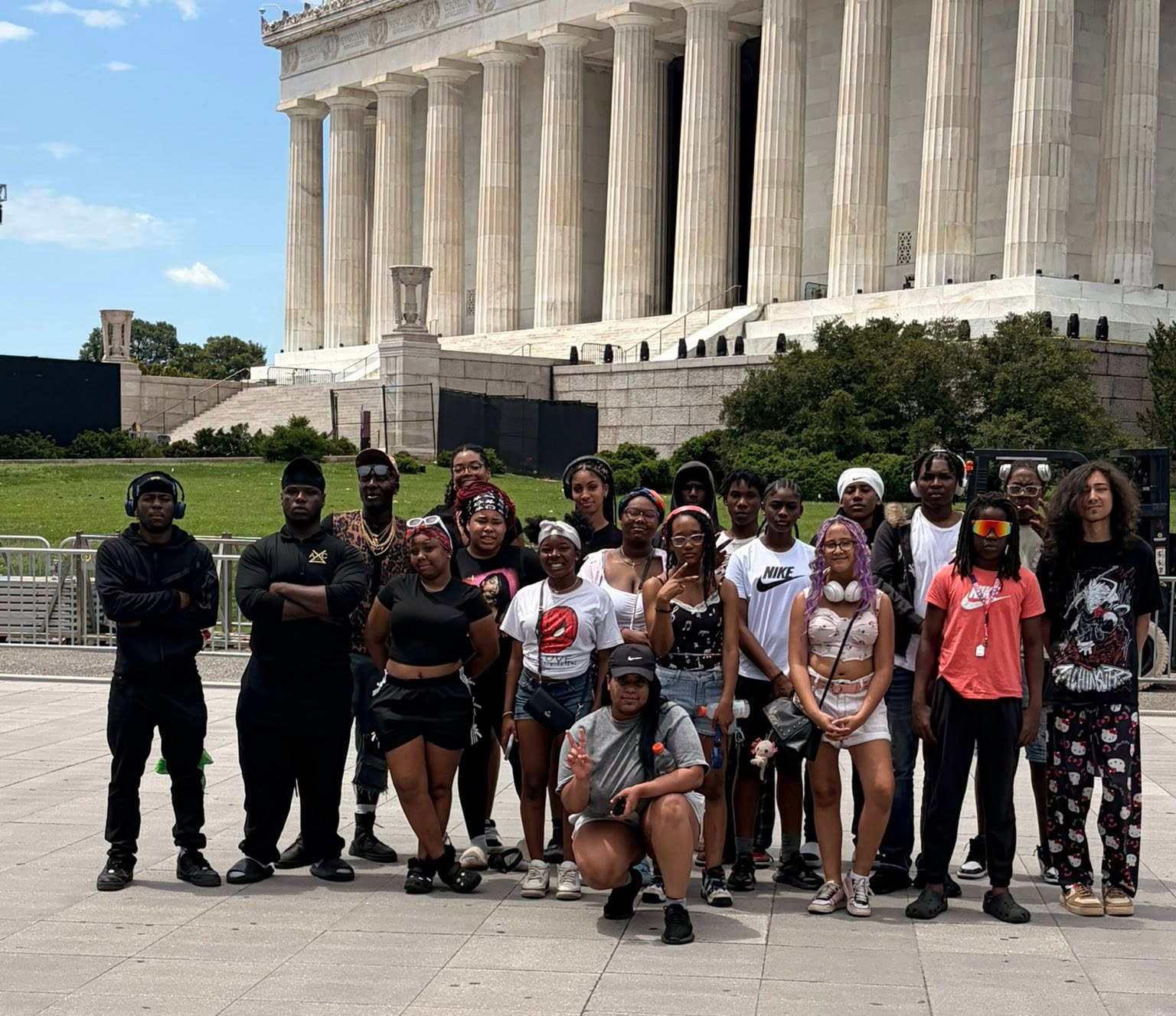 Students smiling in front of a Washington DC monument during their educational trip.