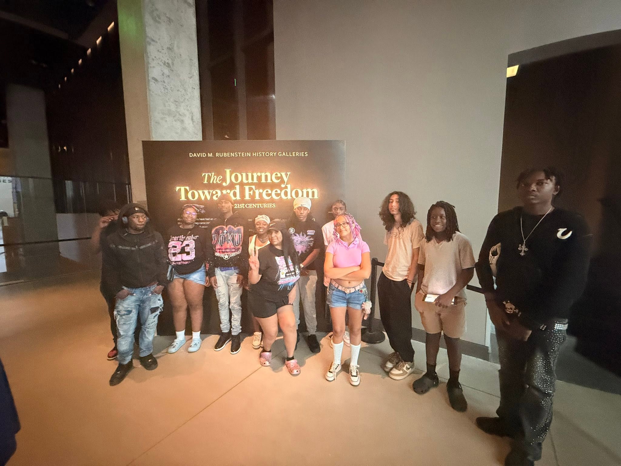 Students smiling in front of a Washington DC monument during their educational trip.
