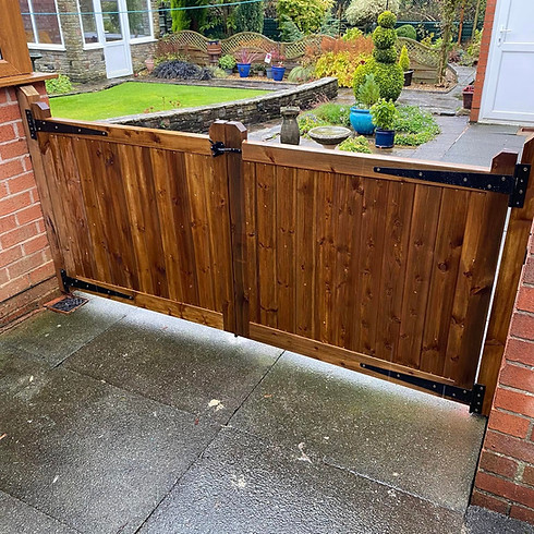 An open wooden gate leads to a house, inviting visitors into the property