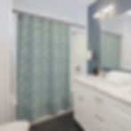 printed shower curtain with small white flowers on an aqua blue background in context