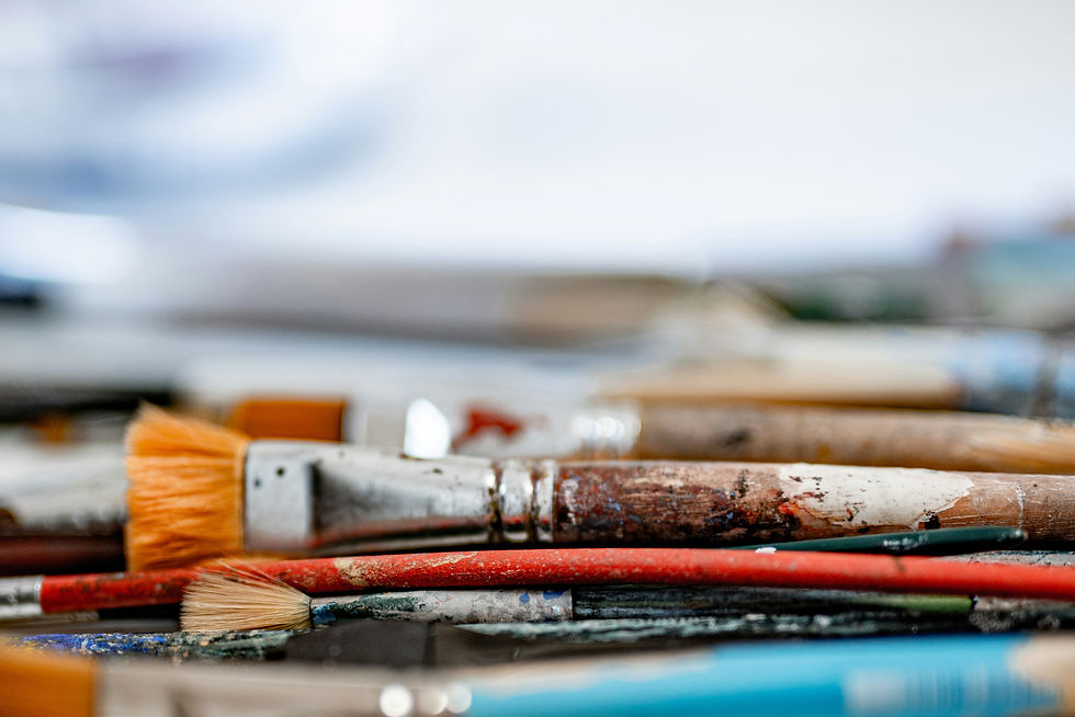 Background depicting old paint brushes laid out horizontally fading into the background