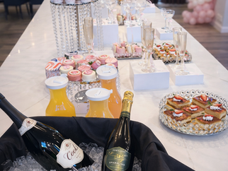 Mimosa Bar with champagne, cupcakes, juice, donuts, and muffins, dessert table
