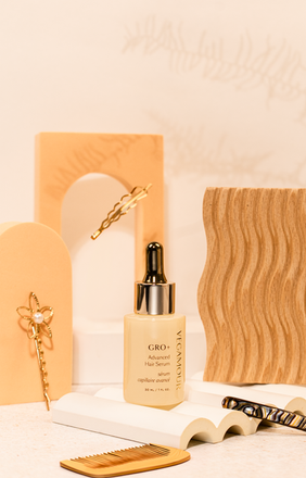 Featured Vegamour Hair Serum with different beige props and hair accessories 