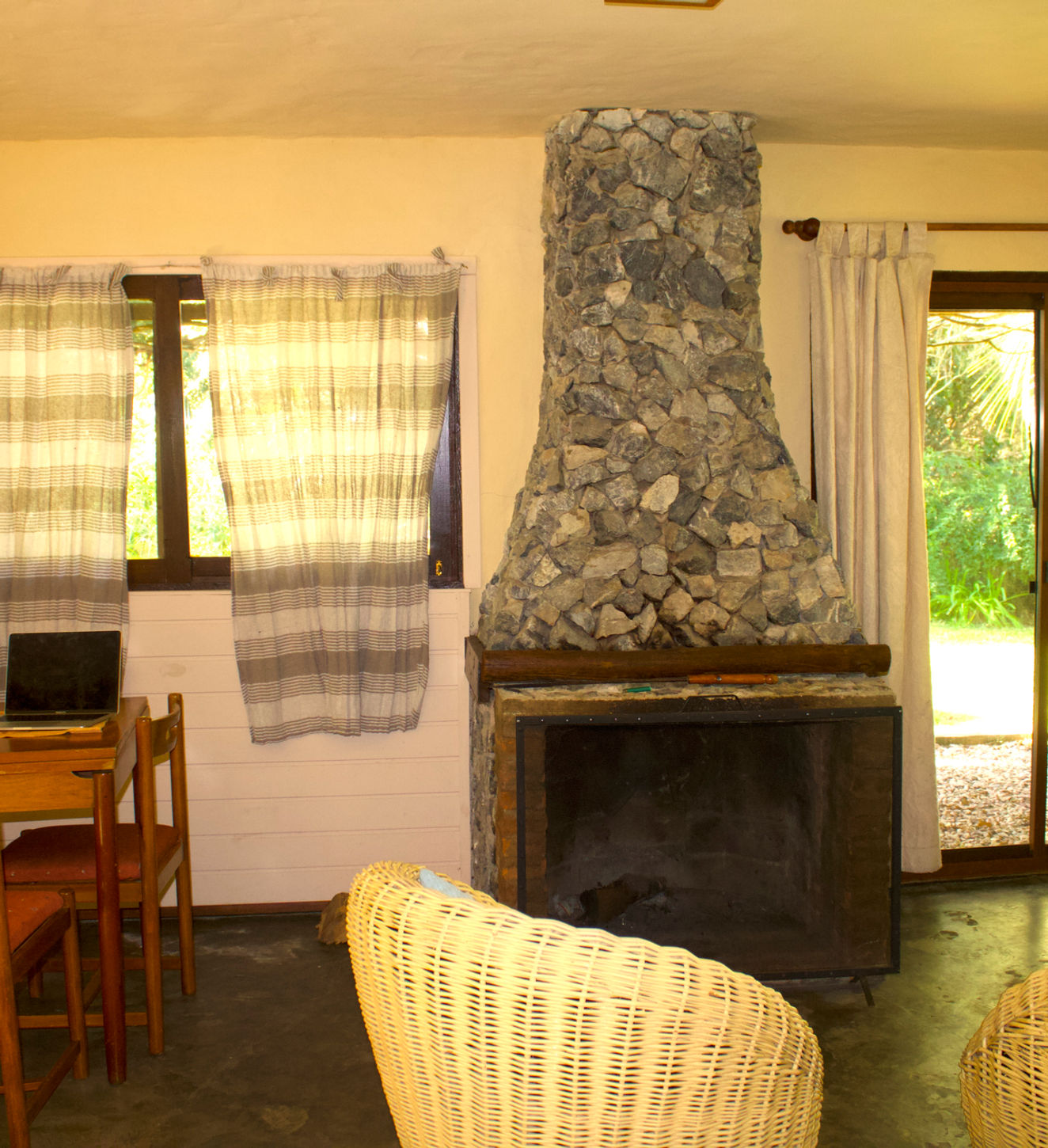 Sala de estar con chimenea, mesa de comedor y sillones.