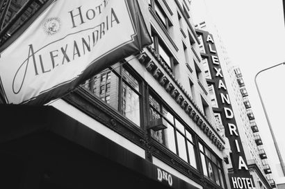 Hotel Alexandria building with "Hotel ALEXANDRIA" banner, "ALEXANDRIA HOTEL" sign.