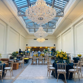 Elegant ballroom interior with two large crystal chandeliers and yellow floral decor.