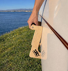 Surfer's grip against a coastal backdrop