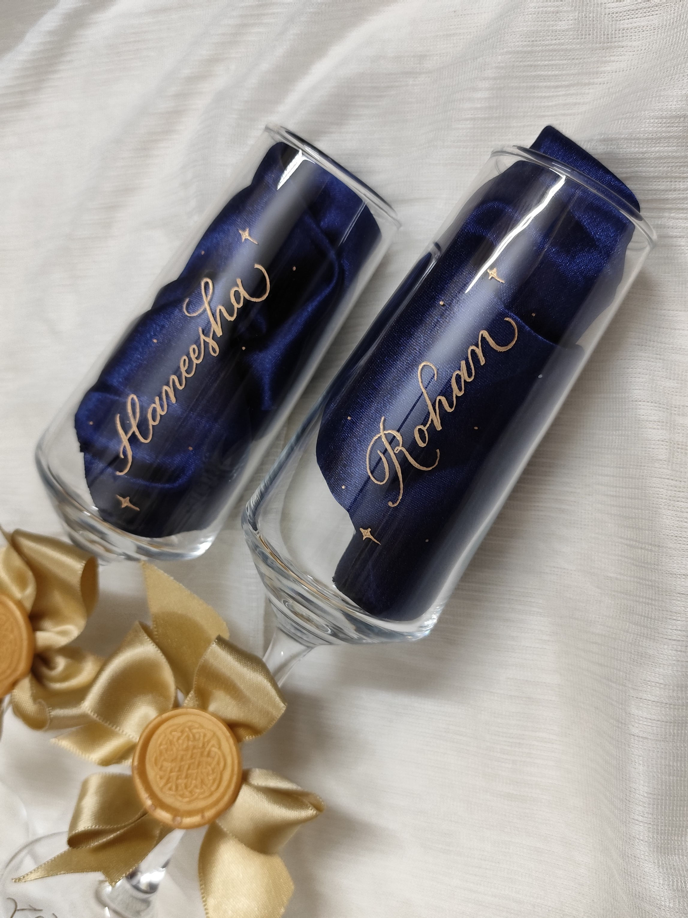 Pair of personalized champagne flutes with custom name engravings.​