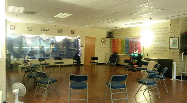 a studio space with a circle of folding chairs in a warm inviting room
