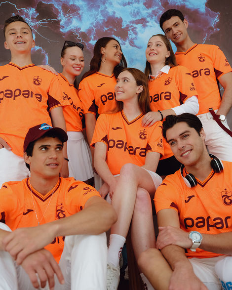 Group of smiling young people wearing orange papara team shirts.