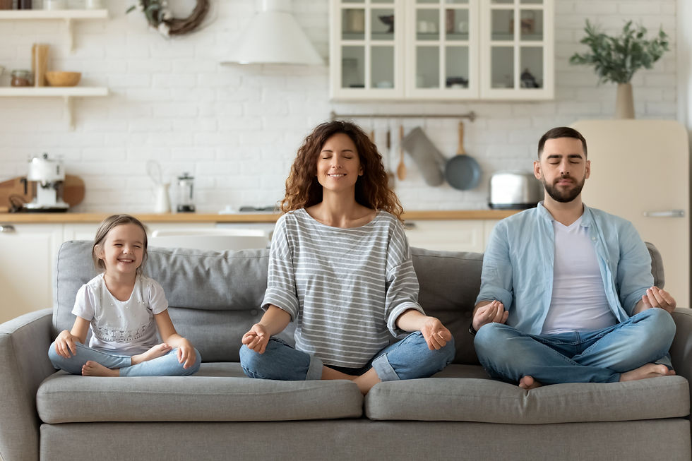 Calm young family with little daughter sit on couch practice yoga together, happy parents 