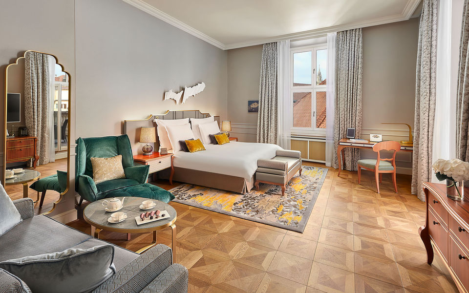 Hotelzimmer im Mandarin Oriental München mit klassischem Interieur, Parkettboden und Sitzbereich