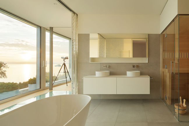 Badezimmer eines luxuriösen Ferienhauses am Bodensee mit freistehender Badewanne und Seeblick