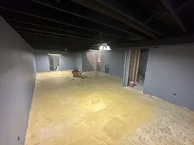 Finished basement renovation with grey walls and black ceiling