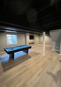 Finished basement with pool table and black exposed ceiling