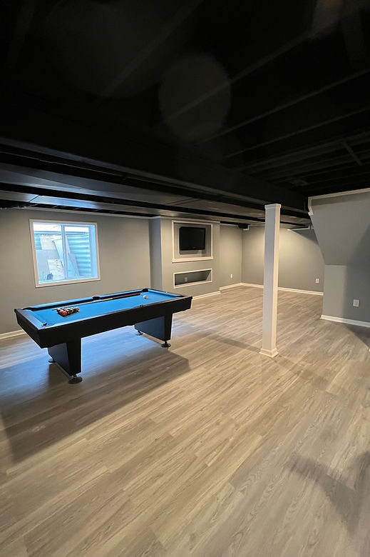 Finished basement with pool table and black exposed ceiling