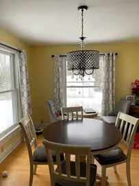 Round dining table with wooden chairs and chandelier