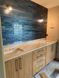 Modern bathroom vanity with wood cabinets and blue backsplash