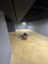 Shop vac in an empty basement with grey walls