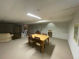 Before pic of basement with dining table and living area.