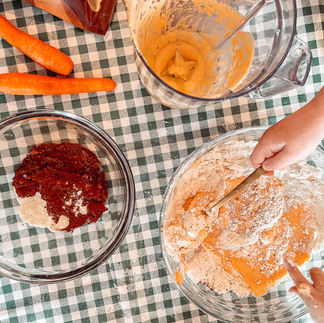 Kids hands hold spoons to fold in a carrot cake batter. Fun easter baking.