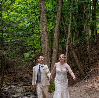wedding couple walking in forest while holding hands
