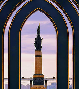 Gothic archway at Stalin Park overlooking the monument. A scenic spot along the Songhua River where the statue silhouettes beautifully against the evening sky