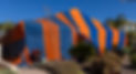 Far shot of a house with a fumigation tent in orange and blue stripes.jpg