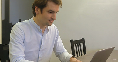 On voit un expert qui a suivi une formation rénovation énergétique des bâtiments sur son ordinateur