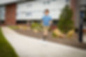 a photo of a oyung man in running motion wearing the biomotum SPARK device