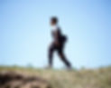 a young boy walking in an outdoor setting on grass wearing the Biomotum SPARK device on both legs.