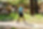 a young boy walking outside on a gravel trail wearing the Biomotum SPARK device on both legs.