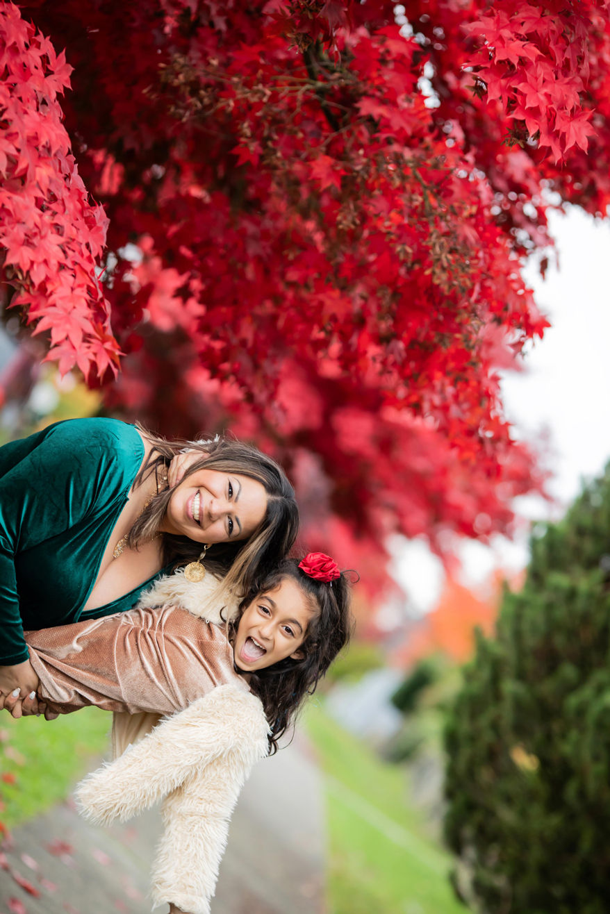 mom and daughter being goofy in the fall leaves