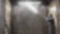 man working with a shot-blasting lance cleaning steelwork, in a booth that is 8x3x3m.jpg