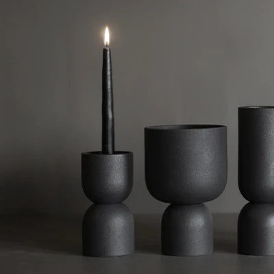 תמונה של פמוט שחור Post Candle עם נר דולק