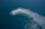 Top view. Boat in turn fast moving aerial view. One boat on blue water drone view. Modern
