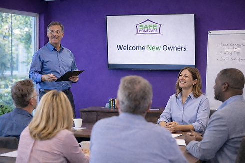 A group of new franchise owners sit around a conference table during an in person training
