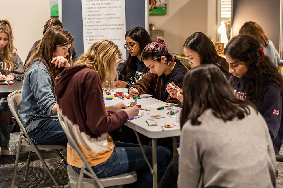 Students seated around a table participating in a group art-making session