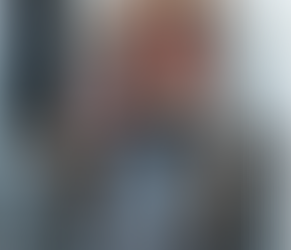 A woman holds a turkey at her Thanksgiving table with an outdoor chandelier.