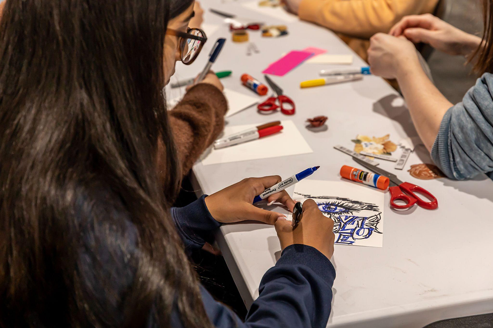Close-up of a student drawing with pens and markers during a classroom activity