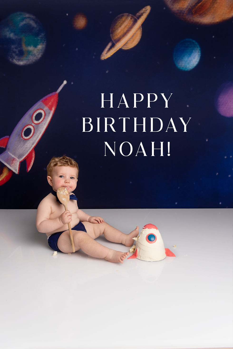 Baby Noah with Space themed backdrop smashing cake at Francesca Weeks Photography